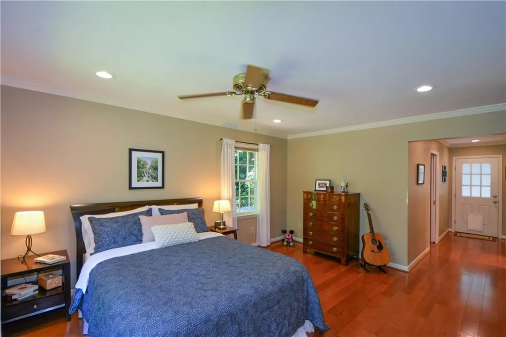 Bedroom featuring dark wood-type flooring, ceiling fan, and crown molding Bedroom featuring dark wood-type flooring, ceiling fan, and crown molding