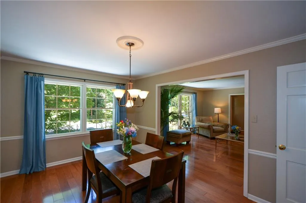 Dining area featuring a chandelier, hardwood / wood-style flooring, and ornamental molding Dining area featuring a chandelier, hardwood / wood-style flooring, and ornamental molding