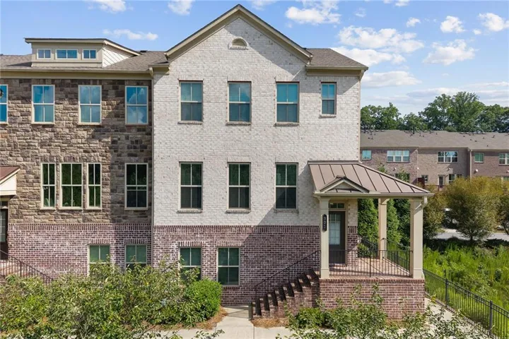 Brick exterior with stone accents, covered entry porch, and multi-pane windows