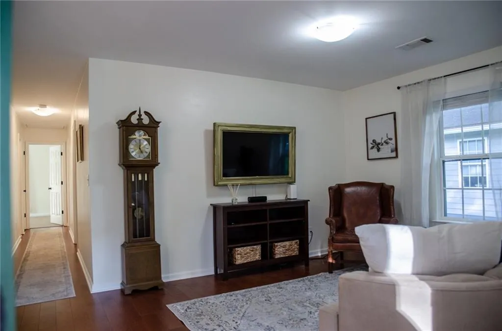 Living room featuring dark wood-style floors and baseboards
