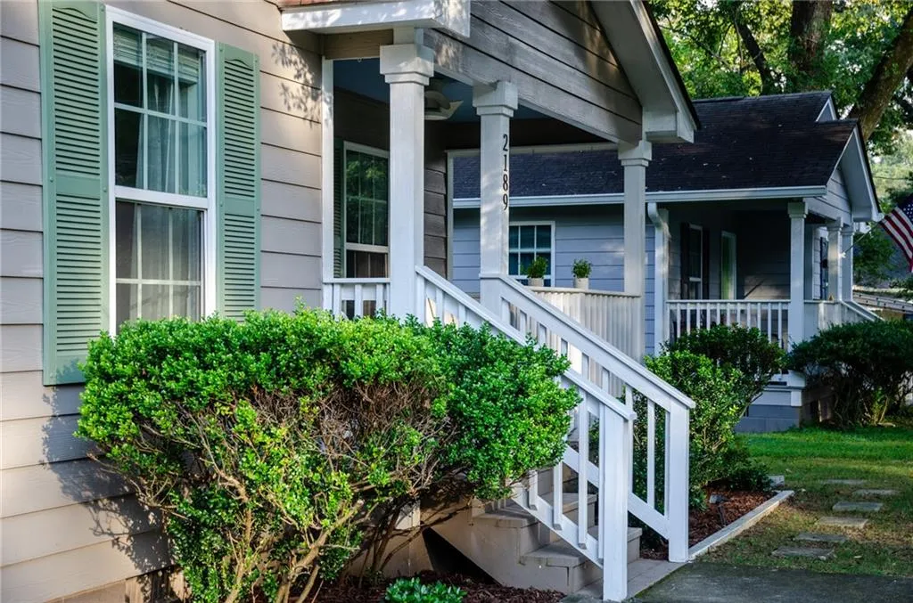 View of side of property with covered porch and a shingled roof