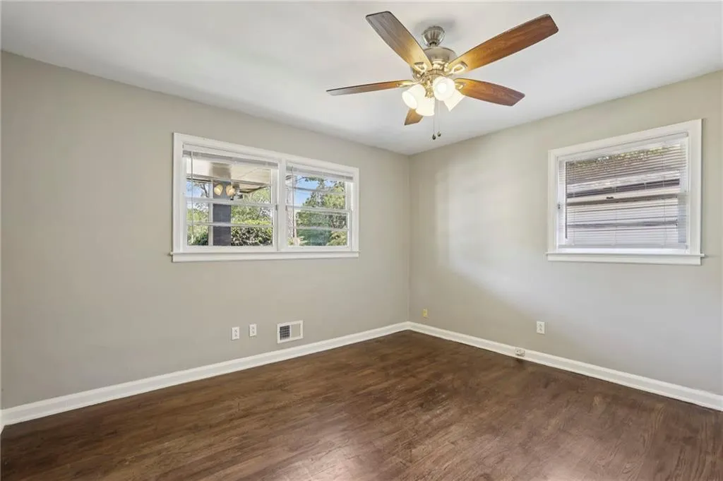 Unfurnished room with dark wood-style floors and ceiling fan