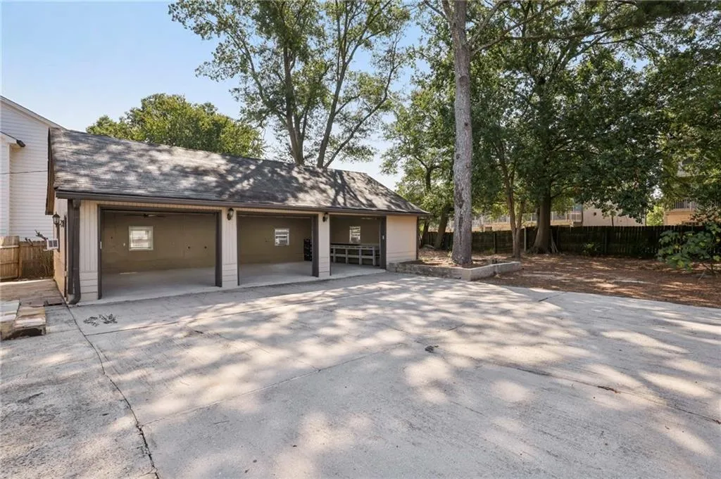 View of property exterior with concrete driveway, roof with shingles, and a garage