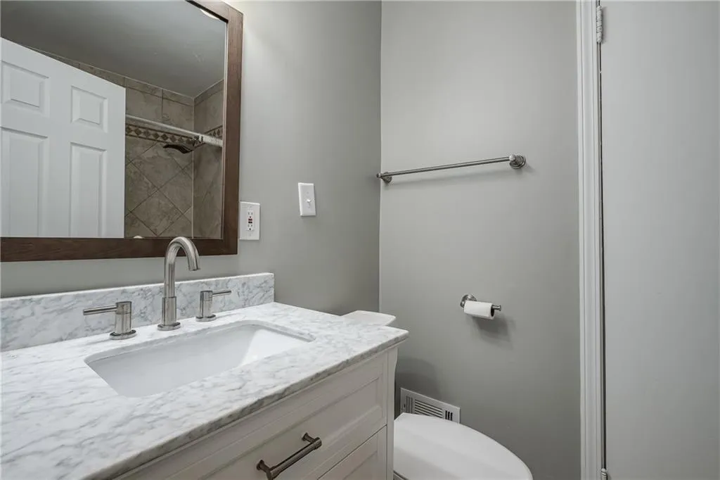 Renovated Hall Bathroom includes a beautiful tiled shower and a marble top vanity