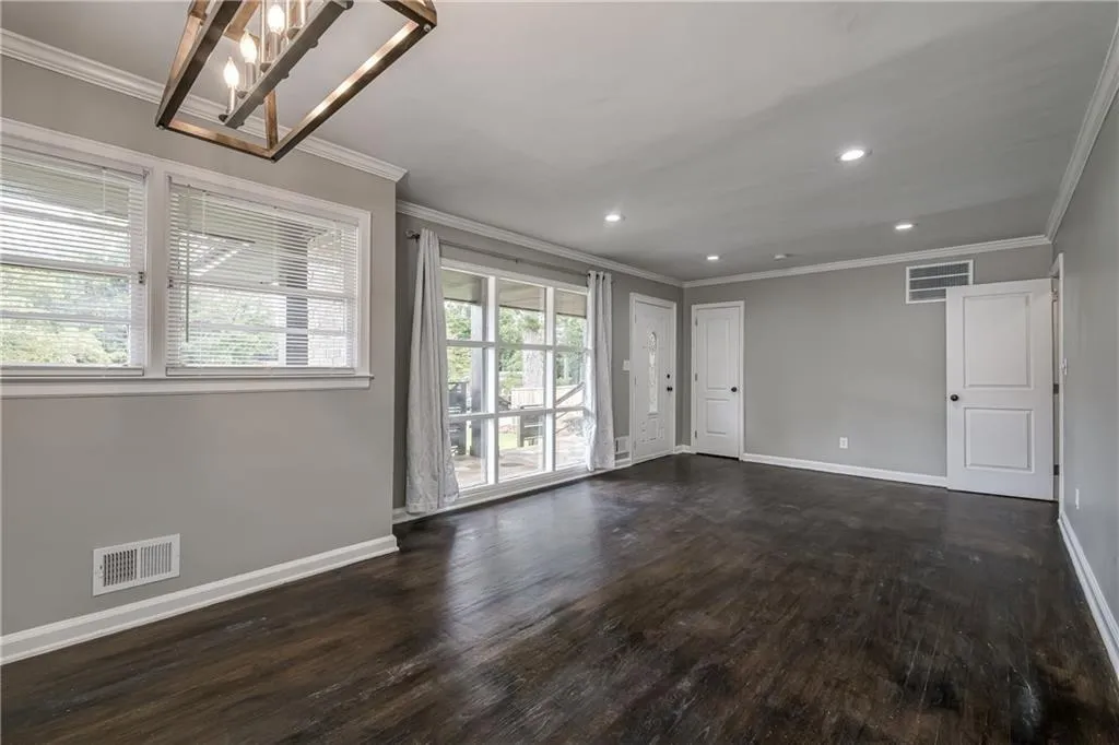 Dining room features modern lighting and hardwood flooring. Floor to ceilng window in adjacent Living Room provides lots of natural light