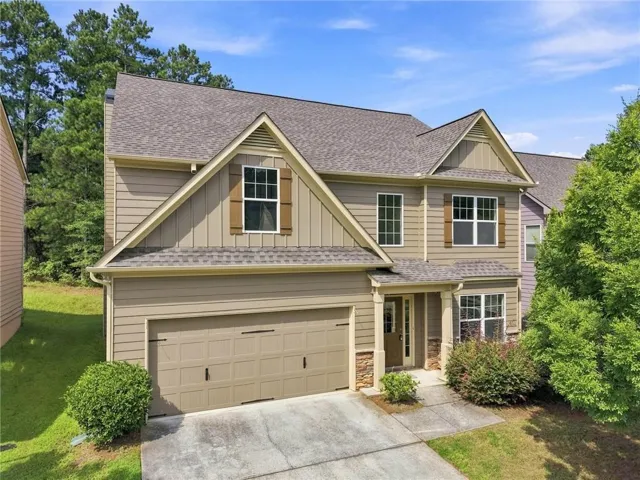 Two-story colonial with cream fiber cement siding and architectural gable detailing