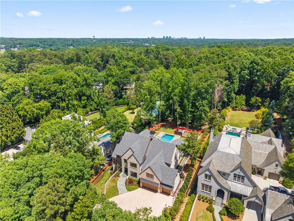 Aerial perspective showcasing the property with a private swimming pool, surrounded by mature trees