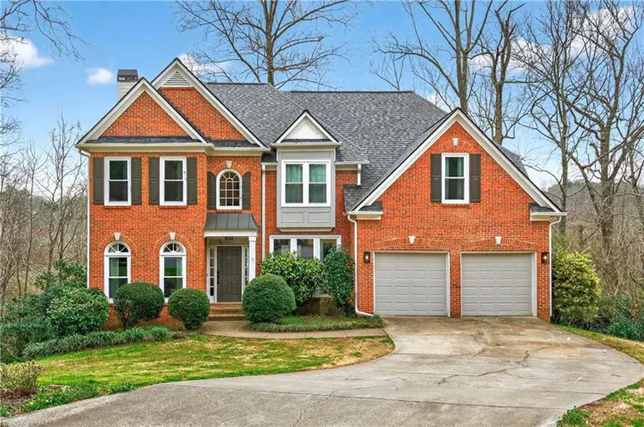 Brick exterior featuring a gabled roofline and a two-car garage