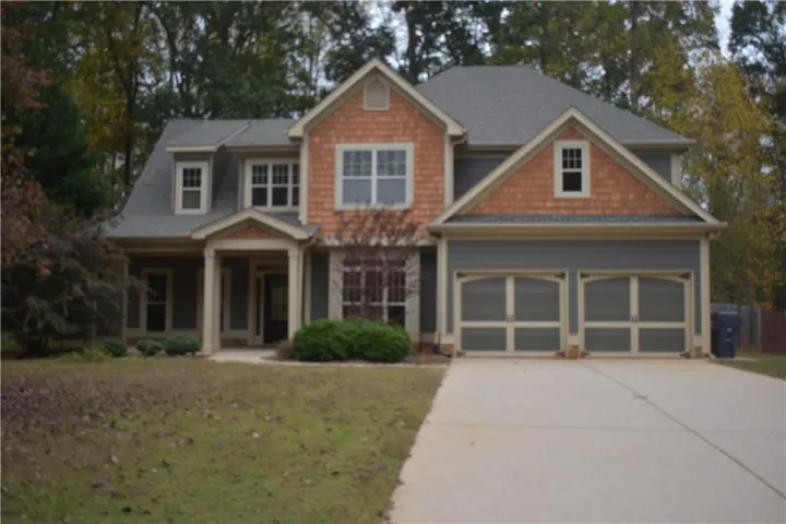 Craftsman-style home with concrete driveway, a garage, and a front yard