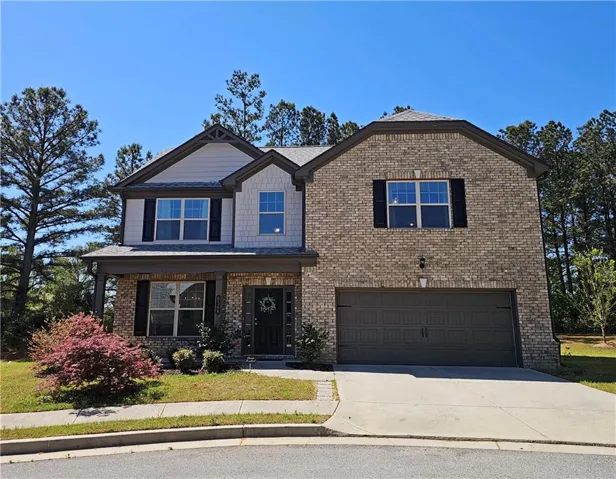 Craftsman-style house featuring an attached garage, driveway, a porch, and brick siding