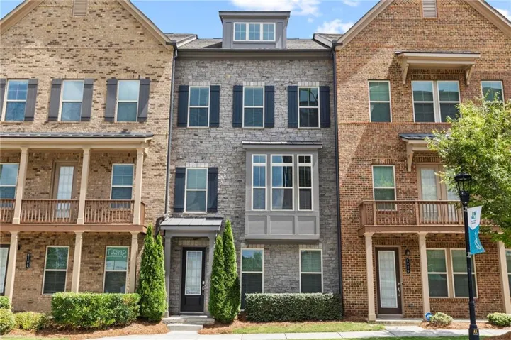 Stone veneer townhome with an articulated facade and upper-level dormer