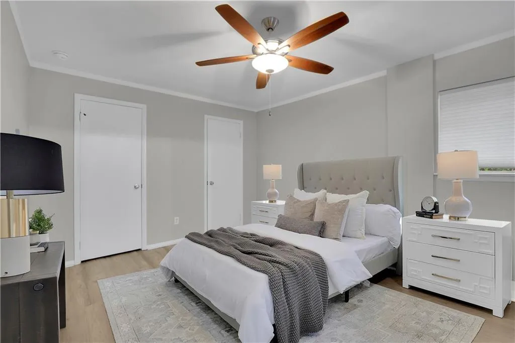 Bedroom featuring ornamental molding, ceiling fan, and light wood-type flooring