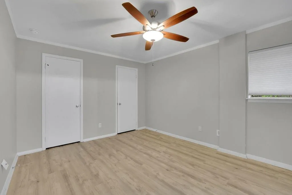 Unfurnished bedroom featuring ceiling fan, light hardwood / wood-style flooring, and crown molding