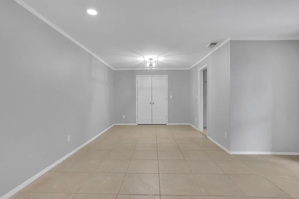 Unfurnished room featuring crown molding and light tile floors