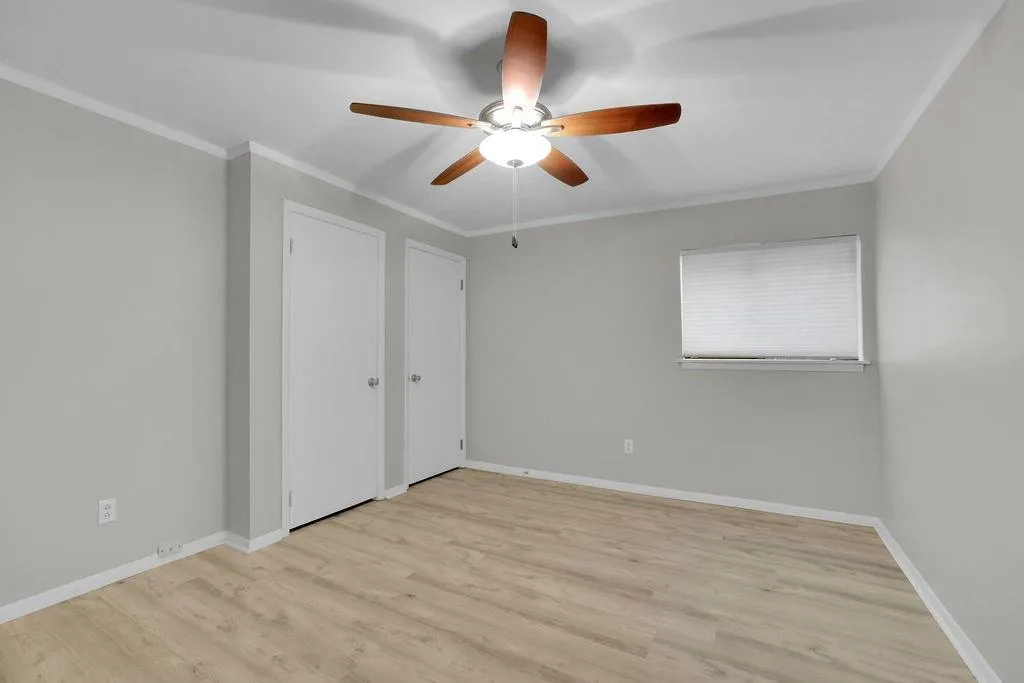 Unfurnished bedroom with light hardwood / wood-style flooring, crown molding, and ceiling fan