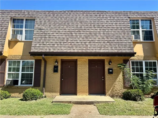 Yellow brick exterior with a brown shingle roof