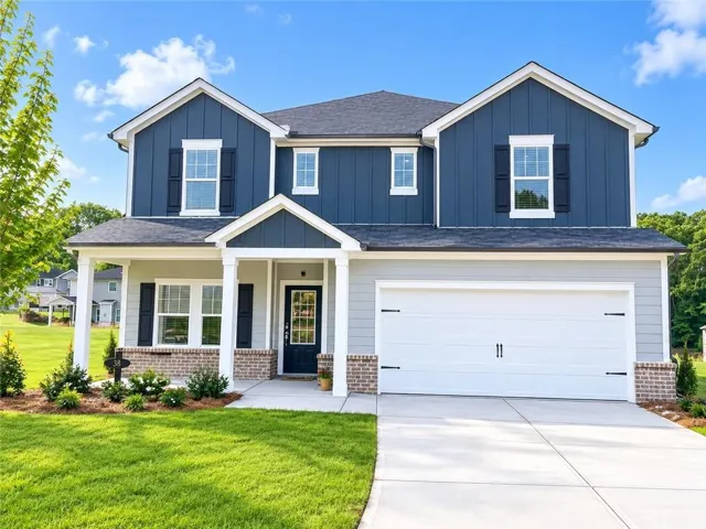 Two-story property featuring a prominent entry porch, a two-car garage, and a concrete driveway