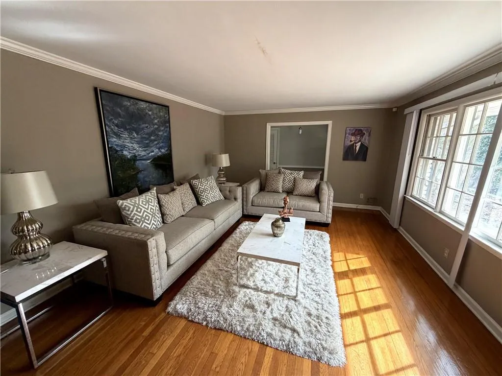 Living area with hardwood / wood-style flooring and crown molding