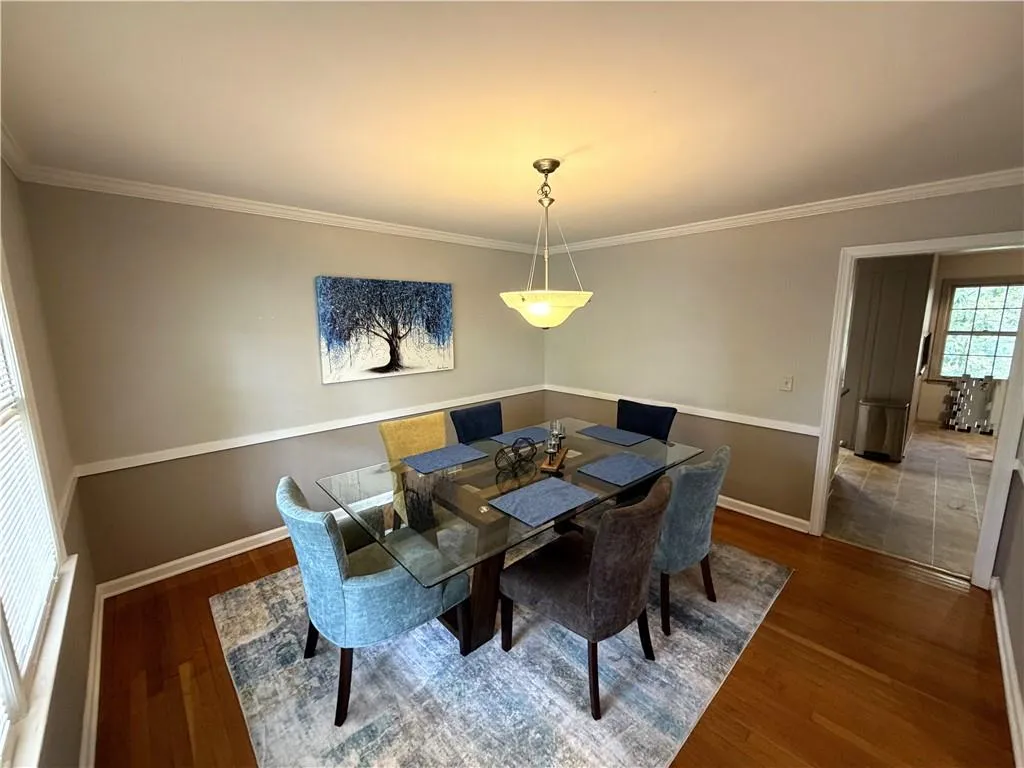 Dining area featuring dark wood finished floors and crown molding