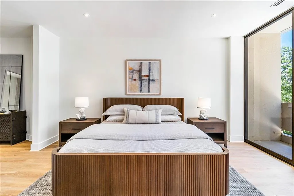 Minimalist room featuring light wood-finish flooring, recessed ceiling lighting, and floor-to-ceiling glass paneling