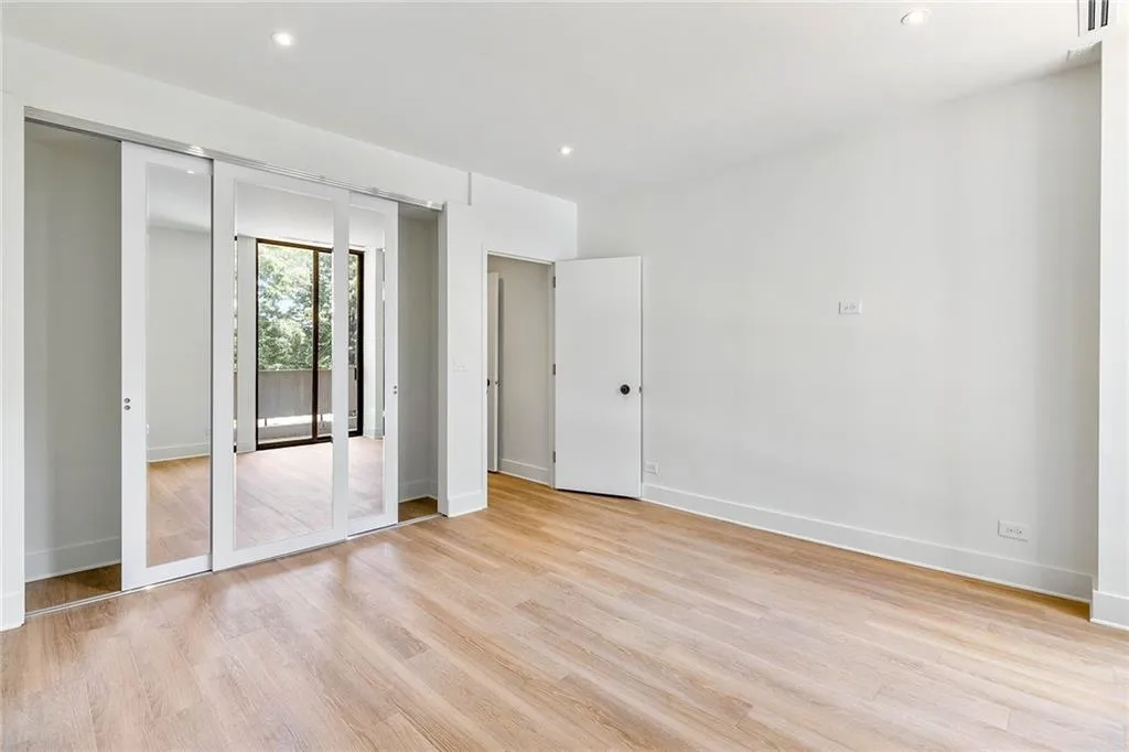Interior space featuring light-toned wood-finish flooring, recessed lighting, mirrored sliding doors, and a neutral color palette