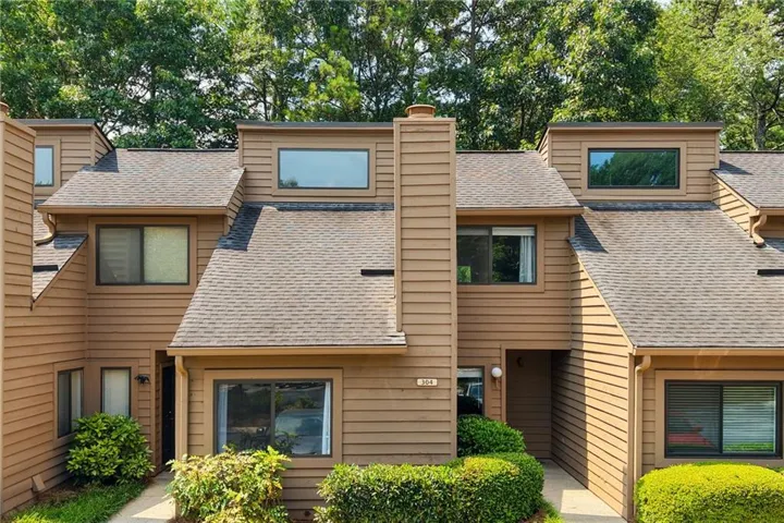 Brown multi-level siding exterior with a prominent central chimney