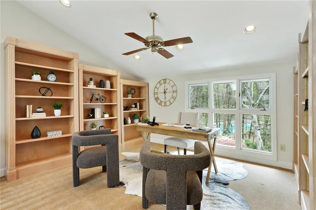 Carpeted office featuring vaulted ceiling, ceiling fan, and a healthy amount of sunlight