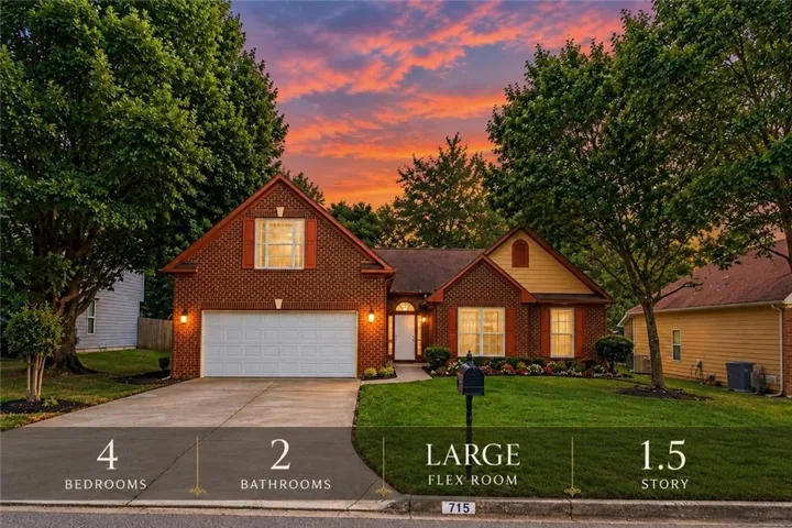 Brick exterior with an attached garage, landscaped front yard, mature trees, and a concrete driveway