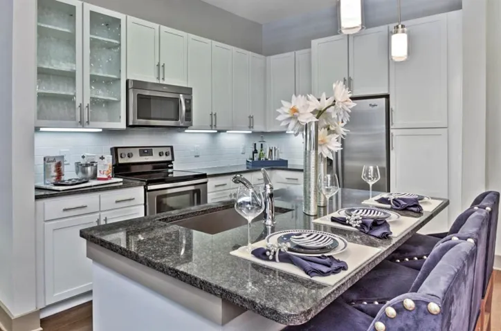 Kitchen with a kitchen breakfast bar, tasteful backsplash, stainless steel appliances, pendant lighting, and sink