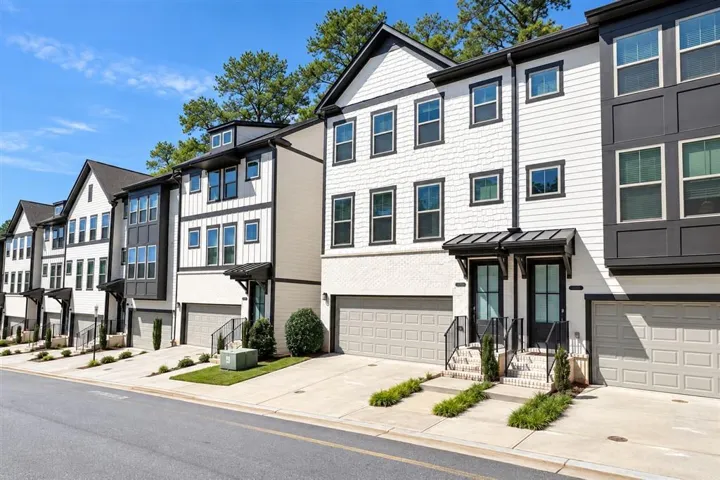 Modern townhome community featuring multi-level facades, private garages, and individual front entries