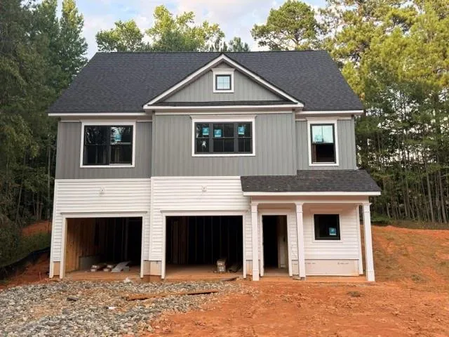 Newly constructed residence featuring a two-tone facade, gable roof, and an integrated two-car garage