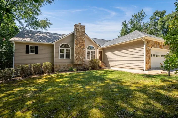 Stone accents and siding exterior with a prominent stone chimney