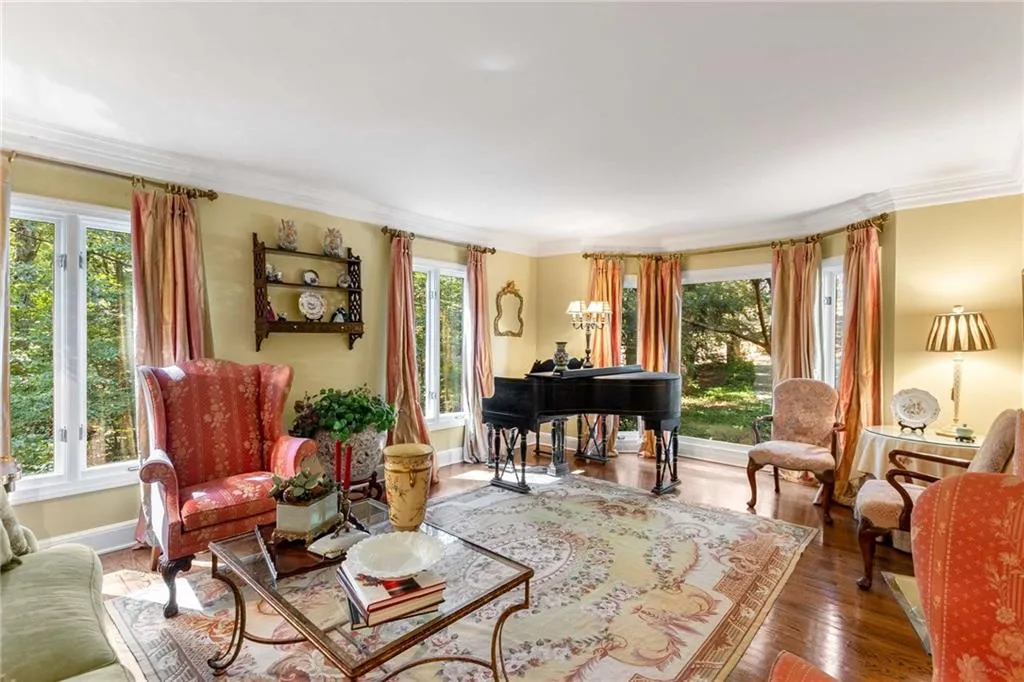 Living room features a beautiful bay window, overlooking a cherry tree, extensive crown molding and hardwood wood flooring.