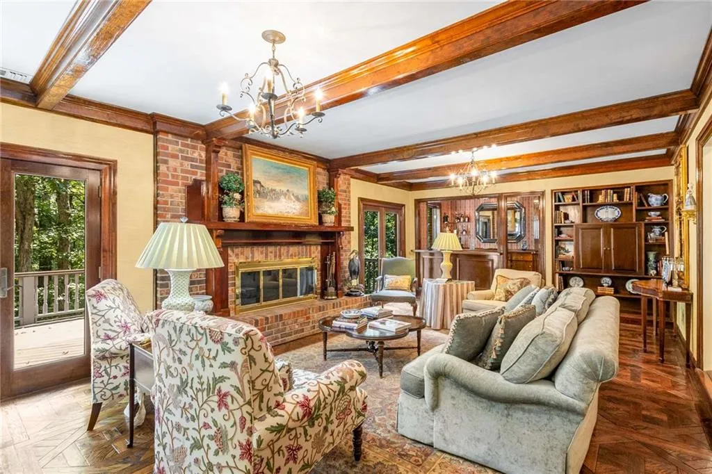 Wood beamed ceiling, a fireplace, parquet floors, wet bar and French doors leadi to the exterior deck overlooking the pool and river.