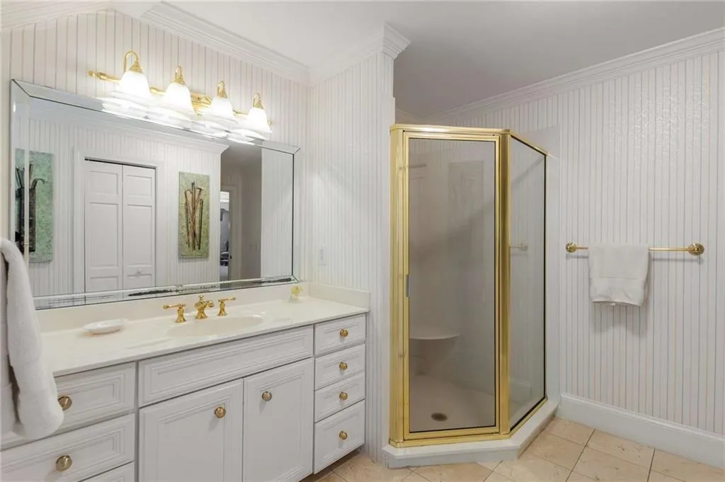 His bathroom has shower and a walk-in closet with access to extra storage.