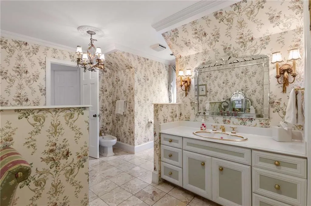 Primary batthroom features a bidet, vanity, crown molding, soaking tub, shower, and 2 walk-in closets for her.