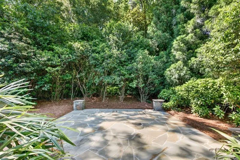 Flagstone patio surrounded by mature trees and lush plantings