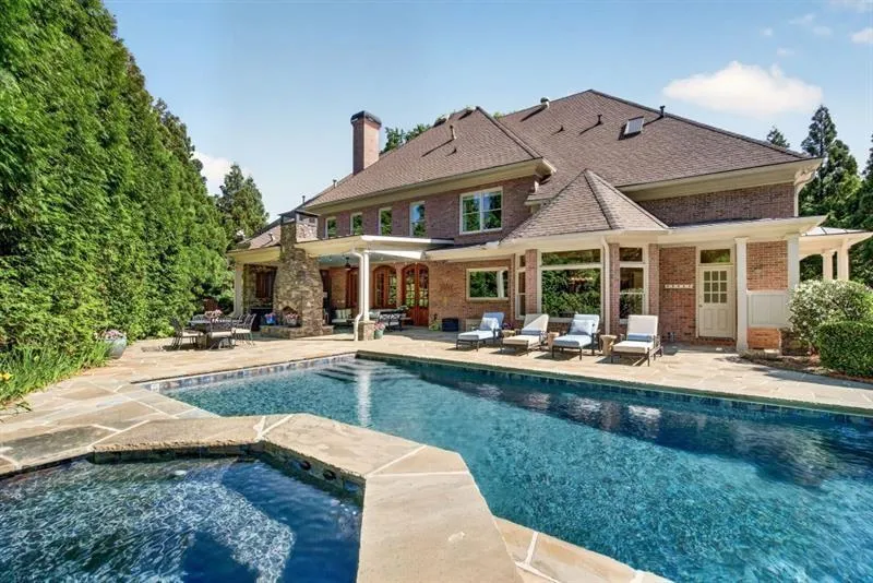 Backyard oasis featuring a swimming pool, integrated spa, and expansive flagstone patio