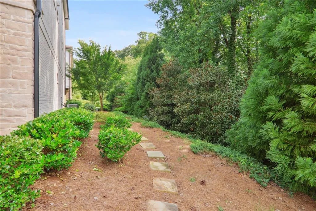 The side of the building leads to community greenspace and a grass yard beyond that.