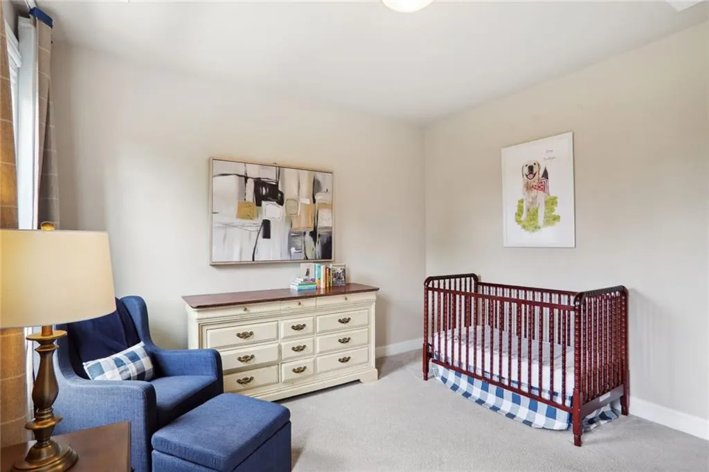Bedroom featuring carpet flooring and a nursery area
