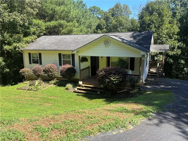 Vinyl siding exterior with a front porch, side entry, and asphalt driveway