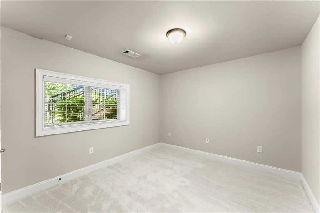 Unfurnished room with light carpet and baseboards
