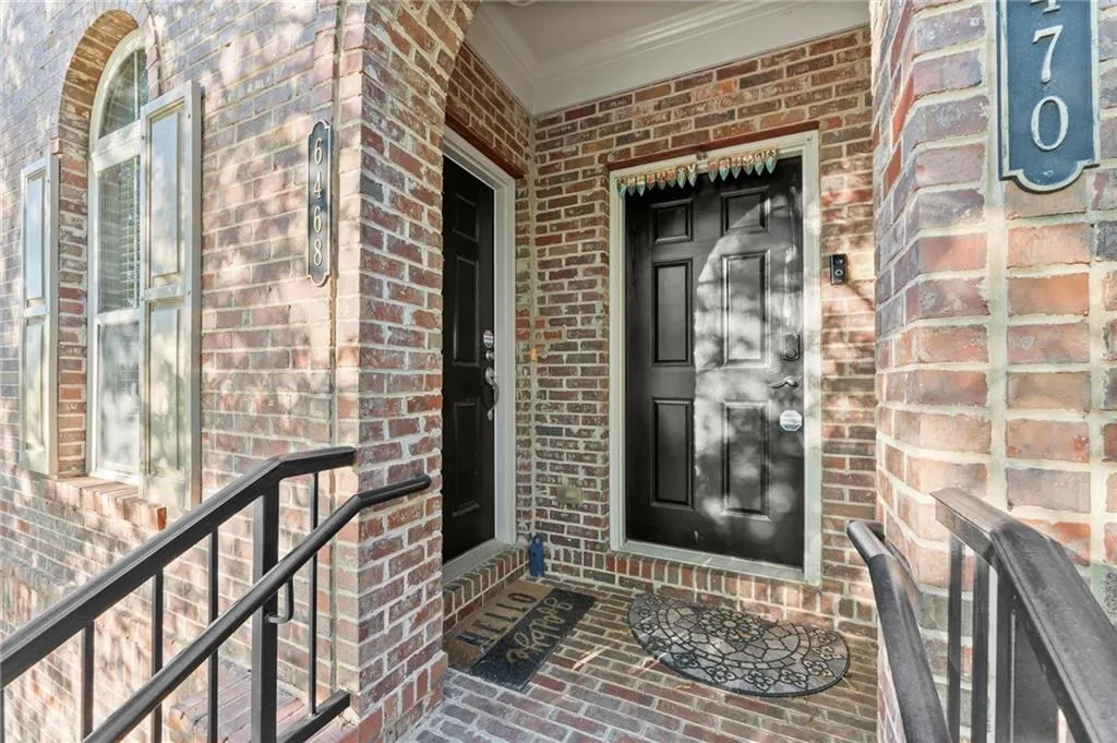 View of exterior entry featuring brick siding and covered porch
