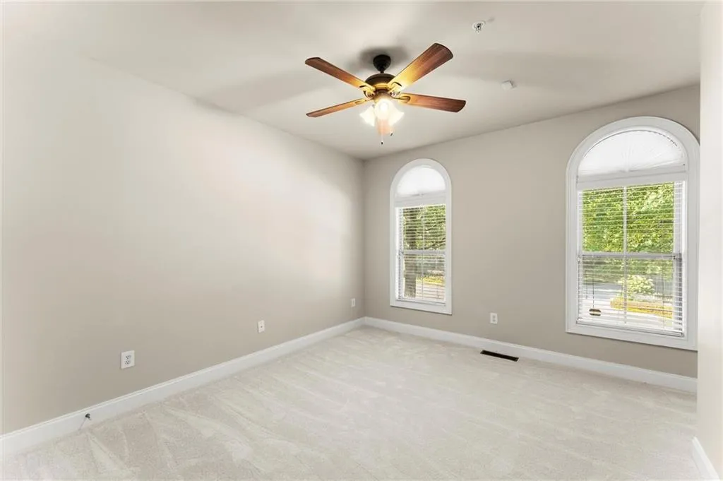 Empty room featuring light carpet and ceiling fan