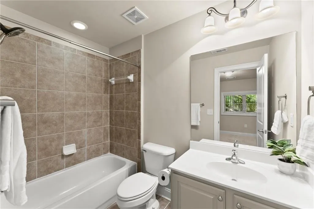 Bathroom featuring vanity, shower / bathtub combination, and recessed lighting