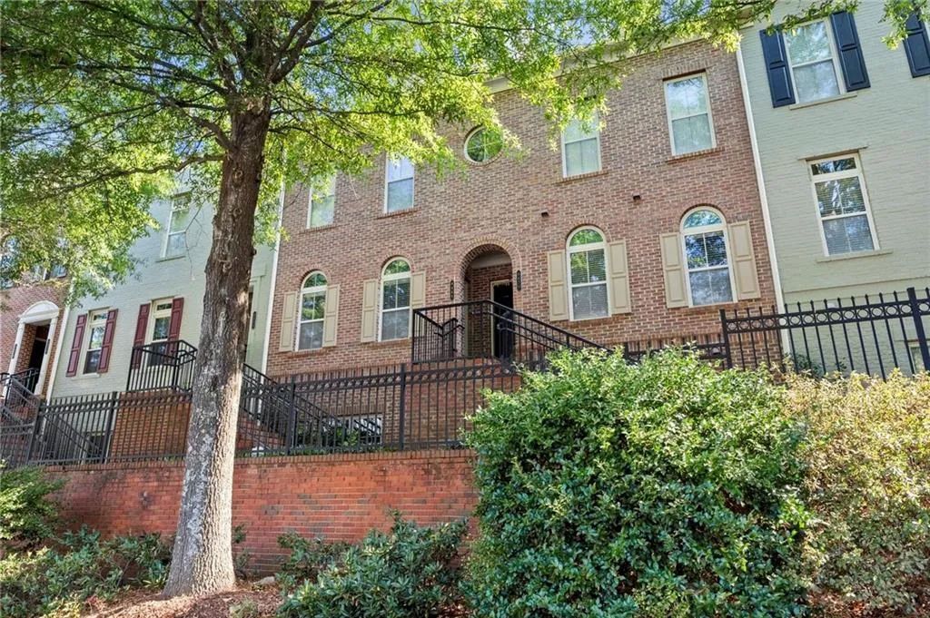 View of front facade with a fenced front yard and brick siding