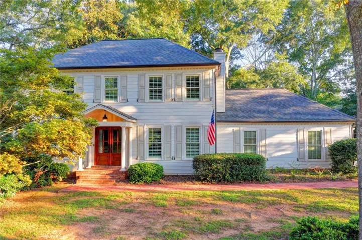 White exterior siding with dark shingle roof and white shutters