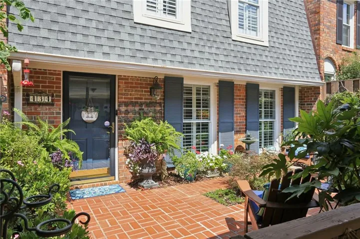 Brick exterior with a gray shingle roof and white dormer windows