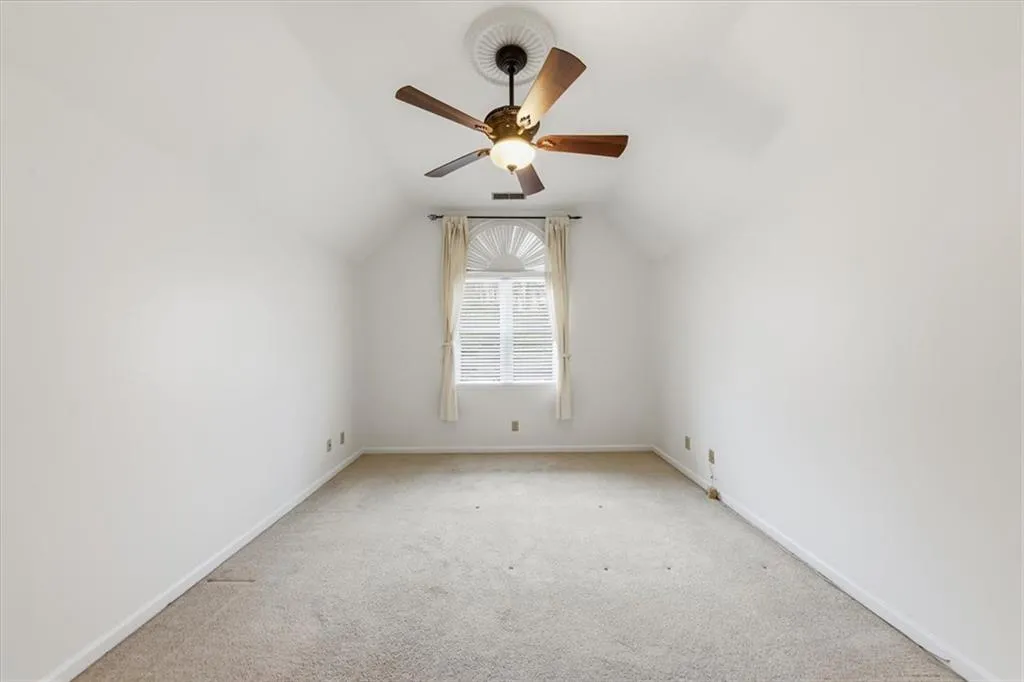 Bonus room with carpet flooring, vaulted ceiling, and a ceiling fan