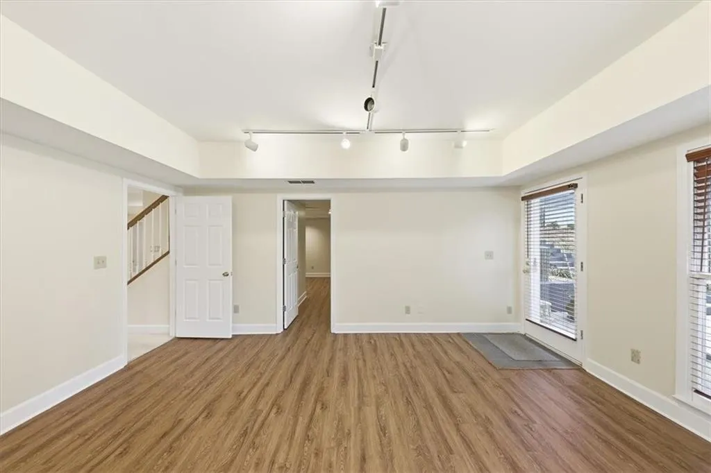 Empty room featuring rail lighting and wood finished floors